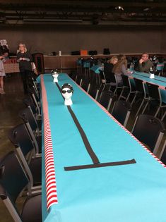 an image of a long table set up for a swim party with people in the background