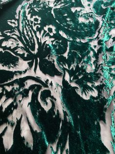 green and white fabric with an intricate design on the top, in shades of teal