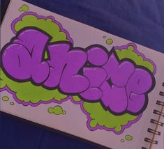 an open notebook with graffiti writing on it