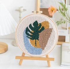 a cross - stitch pattern on a wooden easel with a lamp in the background