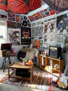 a living room filled with furniture and lots of posters on the wall next to a window