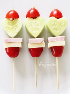 four heart shaped lollipops on sticks with cheese and tomato slices cut in half