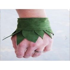 a woman's hand wearing a green leather bracelet