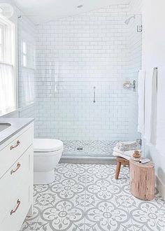 a bathroom with white and gray tiles on the floor