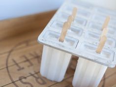 popsicles with toothpicks sticking out of them sitting on top of a wooden table