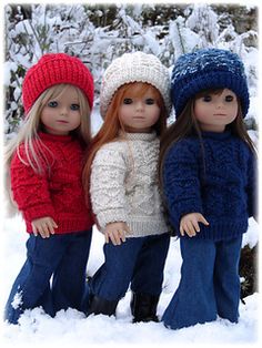 three dolls are standing in the snow together