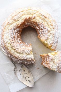 a piece of cake with powdered sugar on top and a spoon next to it