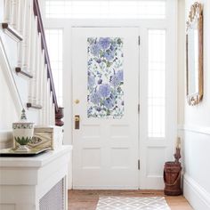 a white door with blue flowers painted on the front and side panels next to it