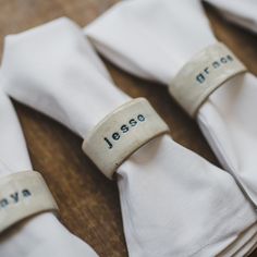 napkin rings with names on them sitting on top of white napkins that say jesso