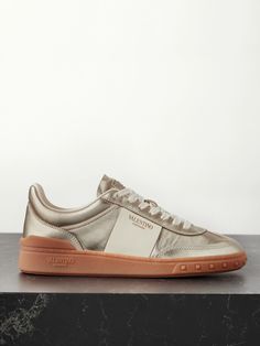 Valentino's silver 'Upvillage' sneakers will instantly elevate anything you wear them with. They've been made in Italy from leather and have ivory panels stamped with the brand's moniker in gold foil lettering. The rubber soles are detailed with signature 'Rockstuds'. Valentino Shoes Sneakers, Valentino Garavani Sneakers, Grey Sapphire, Valentino Sneakers, Striped Flats, Valentino Garavani Shoes, Deep Autumn, Silver Sneakers, Metallic Sneakers