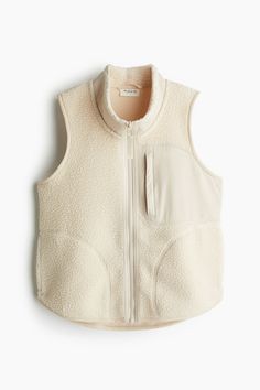 Regular-fit sports vest in soft  warm teddy fleece with elasticized binding. High collar  zipper at front  chest pocket in woven fabric with a zipper  and open handwarmer pockets at sides. Rounded hem. Unlined. Khaki Vest, Teddy Fleece, Cold Outfits, Sports Vest, Cotton Vest, High Collar, Light Beige, Hand Warmers