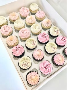 a box filled with pink and white cupcakes