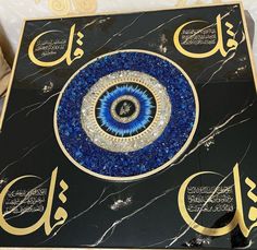 an artistic blue and gold design on a black marbled table with arabic calligraphy