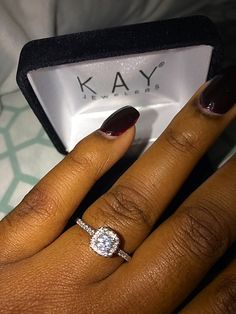 a close up of a person's hand with a diamond ring on their finger