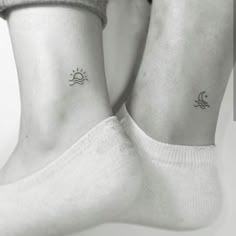 two people with matching tattoos on their feet, one is holding the other's leg