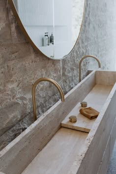 a bathroom sink sitting under a mirror next to a wooden cutting board and soap dispenser