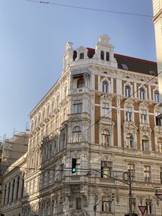 an old building with many windows and balconies on the top floor, in front of a traffic light