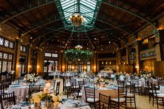 the inside of a large building with tables and chairs set up for an event or function