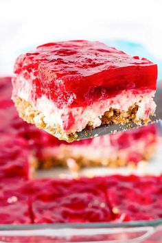 a piece of cake on a fork with raspberry sauce in the middle and white frosting