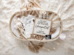 a basket with baby items on it sitting on top of a white blanket and some lights