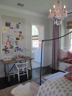 a bedroom with a bed, desk and chandelier hanging from it's ceiling