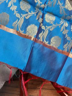 Sky Blue Banarasi Soft Silk Dupatta with Zari Weaved with flower designs all over the dupatta. Note - Dupatta has red tassels on the ends. Item: DupattaBase color : Sky BlueFabric : Banarasi Silk (Non-Pure Silk)Work : Zari Weaved with tasselsWidth of the dupatta - 35 inches (approx)length of the dupatta - 88 inches (approx)Store Policies- No return or exchange will be accepted for color variations.- No return or exchange will be accepted if the color does not match your other clothing or your pa Blue Dupatta With Traditional Patterns For Celebration, Blue Handloom Traditional Wear For Celebration, Blue Silk Dupatta With Dabka Detail, Luxury Blue Katan Silk Dupatta, Blue Silk Dupatta With Motifs, Blue Tussar Silk Dupatta For Celebration, Blue Silk Dupatta With Printed Motifs, Blue Dola Silk Dupatta, Nehru Jackets