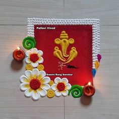 a decorated frame with flowers and candles on a wooden surface for diwaling or decorating