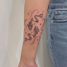 a woman's arm with a dragon tattoo on the left side of her arm