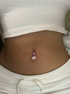 a woman's stomach with a small pink and white cat charm on the side