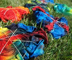 several multicolored pieces of yarn are on the grass