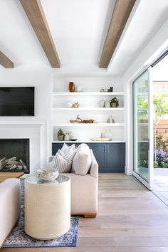 a living room filled with furniture and a flat screen tv mounted on the wall above a fire place