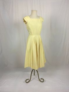 "1950s handmade sun dress yellow cotton w/very subtle leaf motif print sleeveless pullover wide pleated shoulder sleeve square neck/back fitted top w/breast darts side zipper pleated waist good vintage condition, light wear light rust color stains here and there measures, lying flat, shoulder-20\" bust-18 3/4\" (37 1/2\" total) waist-14\" (28\" total) top shoulder to waist-16 1/2\" total length-44\"     We do not offer returns or refunds unless something is grossly misrepresented. Please contact us within 2 business days of receiving to discuss any possible returns for this reason. We do not offer refunds for your shipping fees. Please feel free to contact us with any questions you may have about an item prior to purchase and we will gladly answer them." Spring Cotton Dress With Pleated Bodice, Spring Dresses With Box Pleat, Classic Cotton Summer Dress, Classic Cotton Spring Dress, Solid Color Vintage Cotton Dress, Solid Color Vintage Summer Dress, Summer Cotton Dresses With French Seams, Fitted Yellow Dress With Pleated Bodice, Yellow Fitted Dress With Pleated Bodice