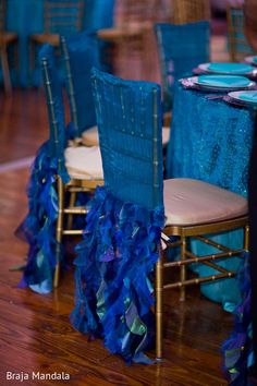 blue chairs with ruffles on them are set up for a banquet or wedding