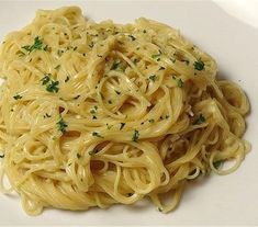 a white plate topped with pasta covered in sauce and parmesan sprinkles