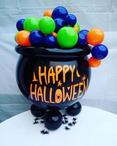 a black caulder filled with halloween balloons on top of a table