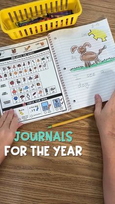 a child's hand is writing on a notebook with the words journals for the year