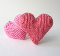 two pink knitted hearts sitting next to each other