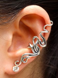 "Spiro Ear Cuff is cast in sterling silver. It is fluid and playful and can be worn on either the left or the right ear. Our model is photographed wearing it on the right ear with the spiral twisting down but it can be inverted and worn on the left ear with the spiral end twisting up. (Diamond not included). Our ear cuffs require no piercings. Starting near the top of the ear, simply slide the cuff down along the edge of the ear's cartilage. If minor adjustments are needed, you may gently open o Ear Cuff Diy, Ear Wrap Earrings, Ear Cuff Silver, Earring Wedding, Wrap Earrings, Swirl Earrings, Earring Trends, Silver Ear Cuff, Statement Earring