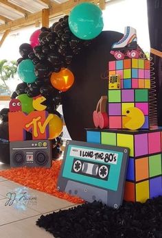 an assortment of colorful objects are on display in a room decorated with balloons and streamers