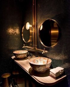 two sinks in a bathroom with mirrors and lights on the wall next to each other