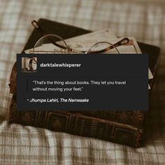 a stack of books sitting on top of a bed next to a pair of glasses