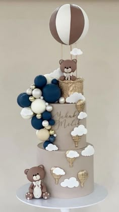 a three tiered cake decorated with balloons and bears