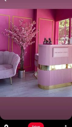 a pink and gold reception desk in a room with two chairs next to each other