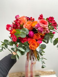 a vase filled with lots of different colored flowers