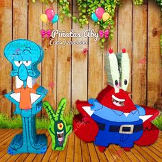 two paper cut outs of cartoon characters sitting in front of a wooden fence