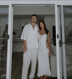 a man and woman standing in front of a sliding glass door