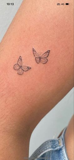 two butterflies tattoo on the back of a woman's arm, one is black and white