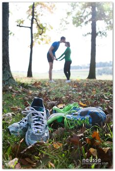 two people standing in the woods with their feet on leaves