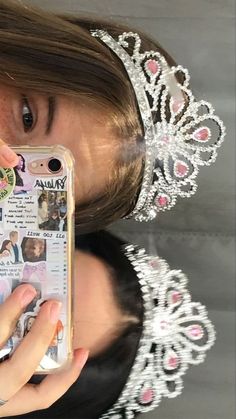 a girl wearing a tiara holding up her cell phone