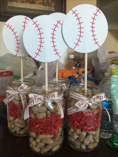 four mason jars filled with nuts and baseball decorations